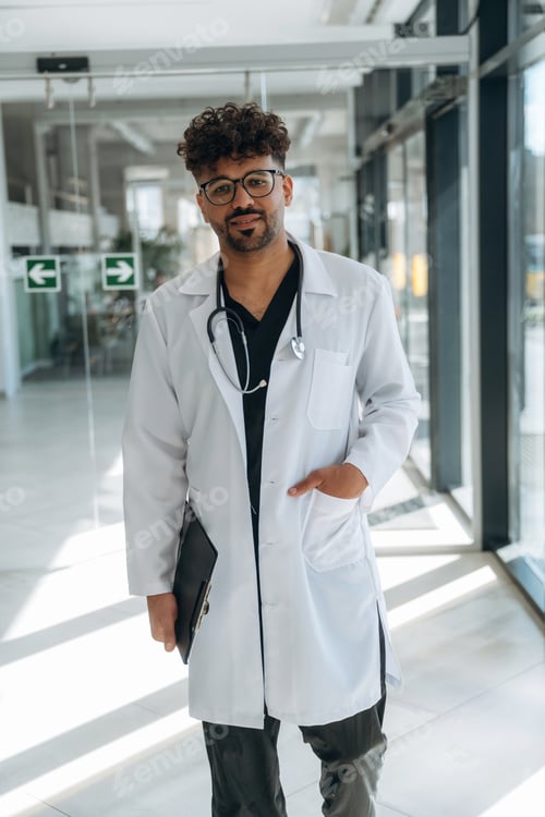 Preview: In white coat. Doctor is indoors in the modern building