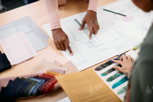 Preview: Close-up of fashion designers working on new project in clothing studio.