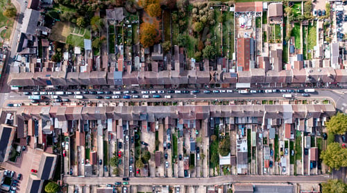 Preview: Aerial view directly above a long city street with terraced houses and gardens