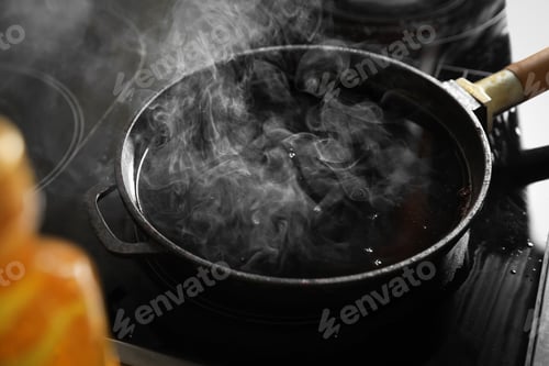 Preview: Frying pan with hot used cooking oil on stove