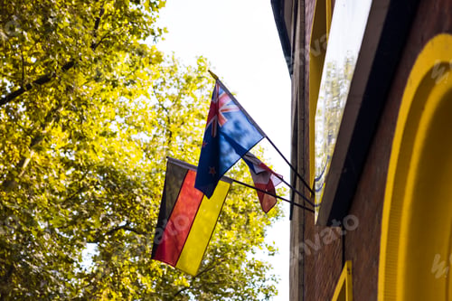 Preview: National flags of Germany and New Zealand hanging on flagpoles on building