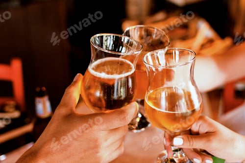 Preview: Close-up image of friends holding beer glasses. Group of people clinking beer glasses.