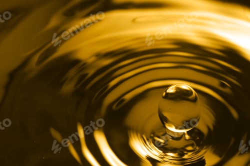 Preview: Splash of golden oily liquid with drop as background, closeup