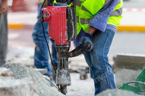 Preview: Man drilling the asphalt in the street, closeup on hands and instrument
