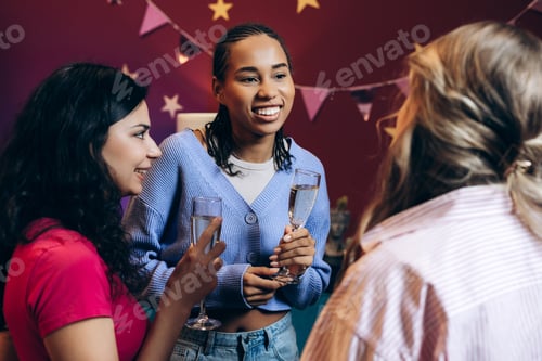Preview: Diverse women friends celebrating with champagne at party