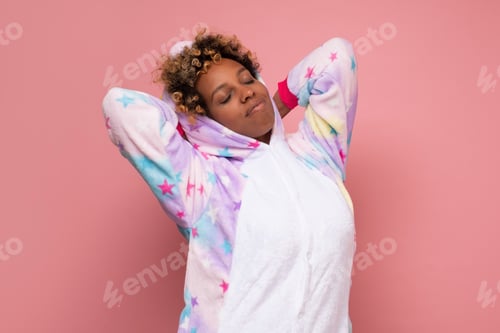 Preview: Tired african woman in pajamas stretching after napping.