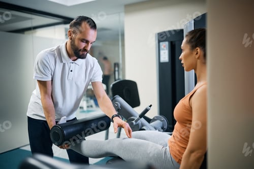 Preview: Woman Training Legs with Gym Instructor Assistance