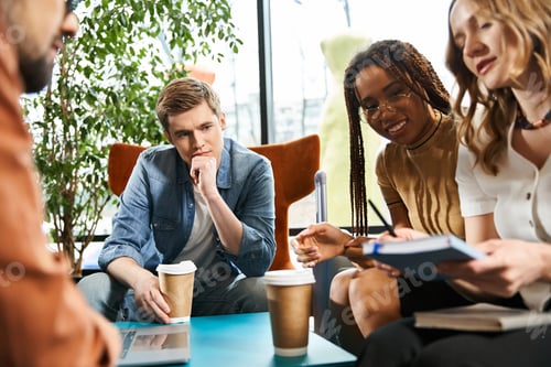 Preview: Multicultural colleagues brainstorming ideas at hotel lobby table