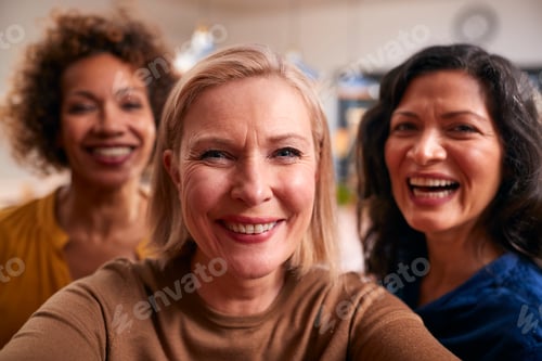 Preview: Group Of Mature Female Friends Posing For Selfie On Mobile Phone At Home
