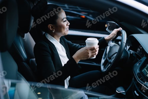 Preview: Happy entrepreneur driving car drinking coffee
