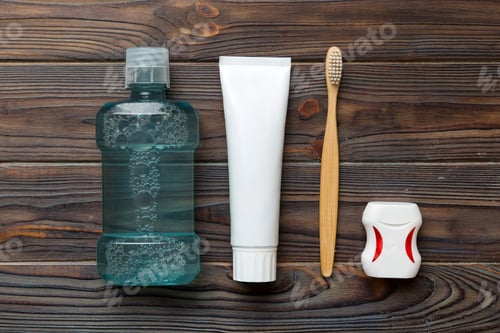 Preview: Mouthwash and other oral hygiene products on colored table top view with copy space.