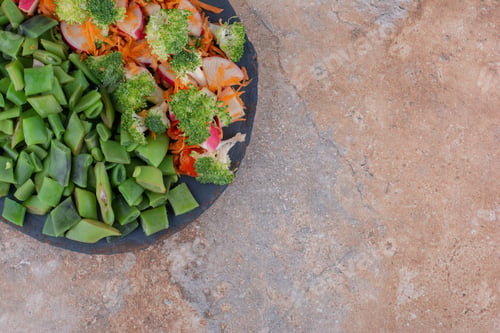 Preview: Tray of mixed vegetable salad and chopped bean pulses on marble background