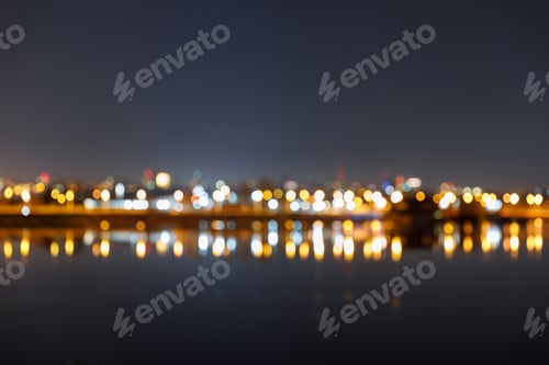 Preview: dark cityscape with defocused illuminated buildings and river