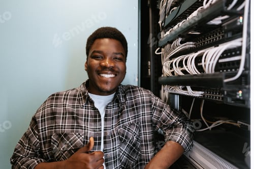Preview: Young technician smiling confidently while working in server room