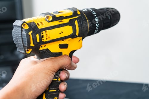 Preview: Holding a Yellow and Black Cordless Drill