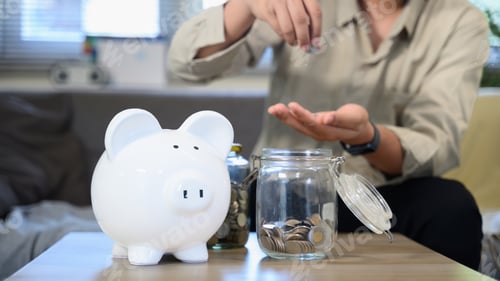 Preview: Piggy bank savings with a man holding a coin