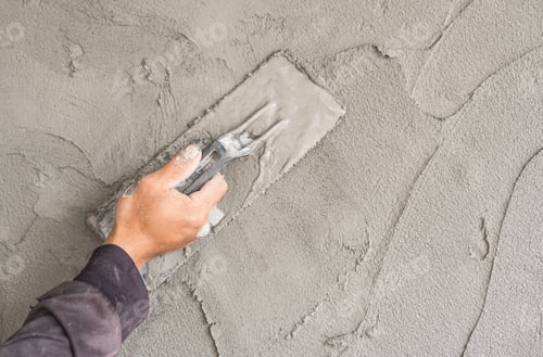 Preview: Hand plaster plastering with trowel handle wet grey cement wall background well free space for text