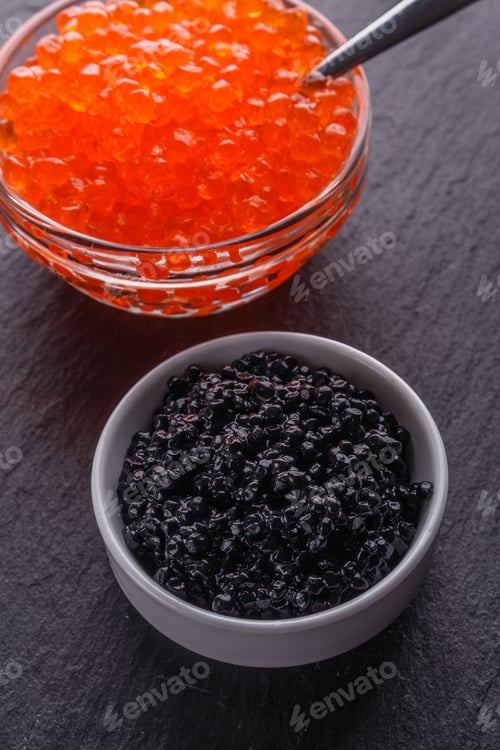 Preview: red and black caviar in a bowl on a dark stone background