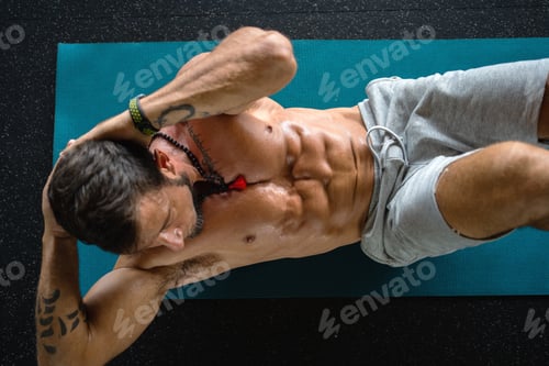 Preview: Man doing crunches on a mat in a gym