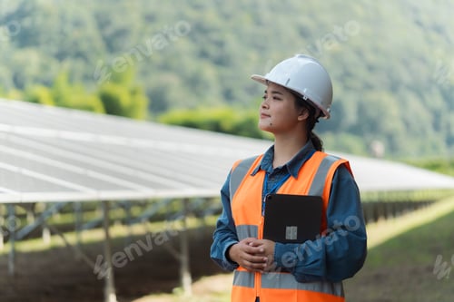 Preview: Female electrical engineer using laptop to check solar panel farm equipment, eco-friendly energy