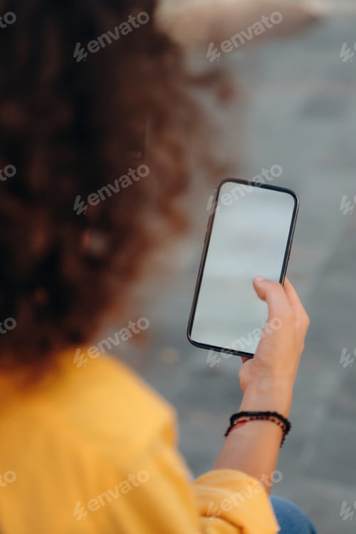 Preview: Woman is sitting and holding copy space smartphone, internet connection conception
