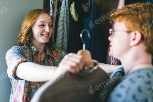 Preview: Happy couple choosing clothes next to the wardrobe
