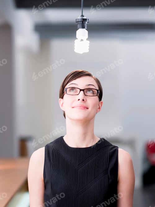 Preview: Woman looking at a light bulb