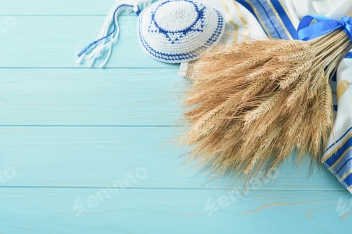 Preview: Shavuot jewish holiday celebration. Bouquet of golden ripe wheat with blue ribbon. White wood board