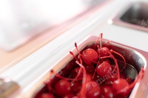 Preview: Close up photo of a metal tray filled with cherry toppings on an ice cream parlor counter