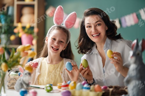 Preview: Mother and Daughter Smiling While Painting Easter Eggs for Festi