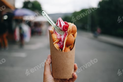 Preview: Woman hold out bubble waffle dessert