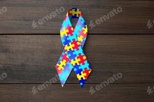Preview: World Autism Awareness Day. Colorful puzzle ribbon on wooden background, top view