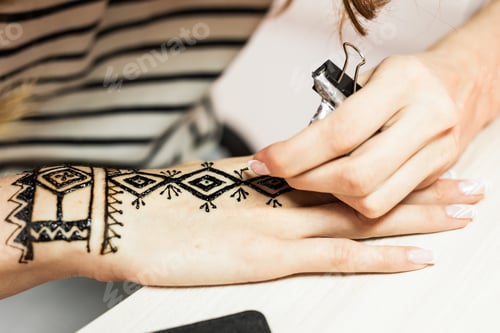 Preview: Process of applying Mehndi on female hand close up