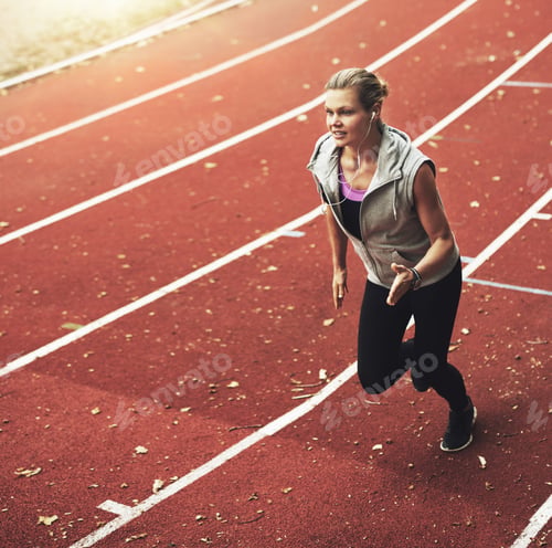 Preview: Portrait of young sportswoman running fast on track field