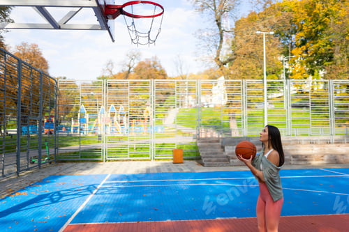 Preview: Female basketball player getting ready to make a ball throw to the basket