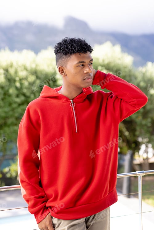Preview: Image of biracial man in red hooded top with copyspace over trees in background