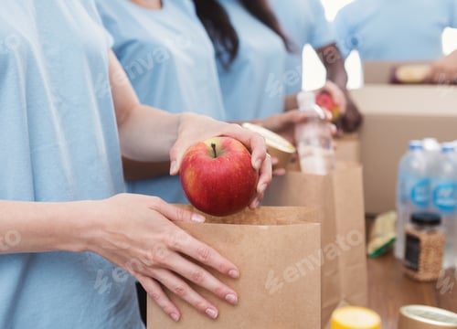 Preview: Volunteers packing food and drinks into paper bags