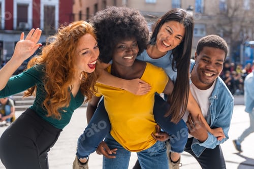 Preview: Happy multiethnic friends in the city with rise on the back and smiling taking a selfie