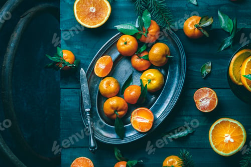 Preview: Tangerines with green leaves on a green wooden table in a rustic style surrounded by spruce branches