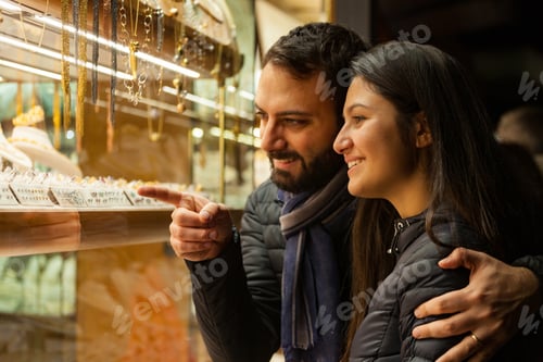Preview: Couple looking at the showcase of an outdoor jewelry.