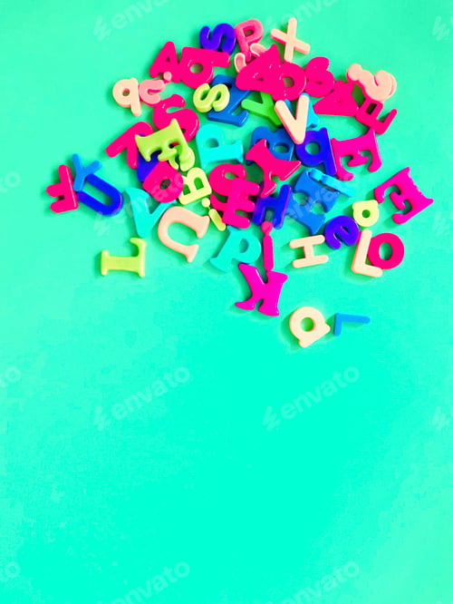 Preview: Colorful alphabet fridge magnets on colourful background with space for copy
