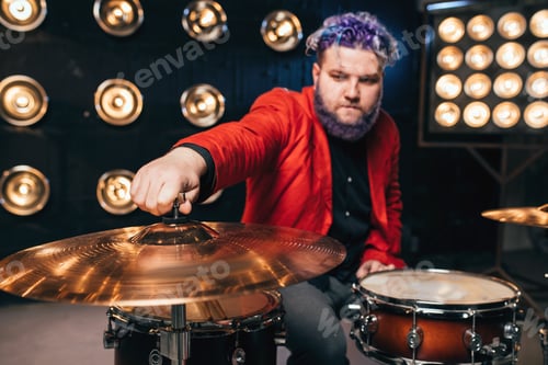 Preview: Bearded drummer in red suit on the stage