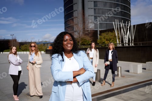 Preview: African-American businesswoman smiling in front of her business team.