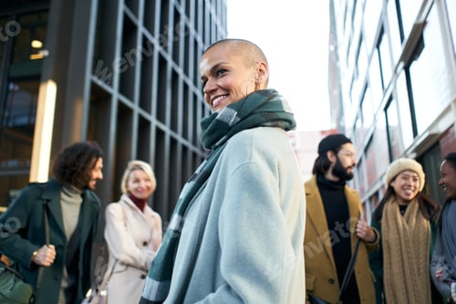 Preview: An empowered and confident business woman looking at camera smiling through the crowd