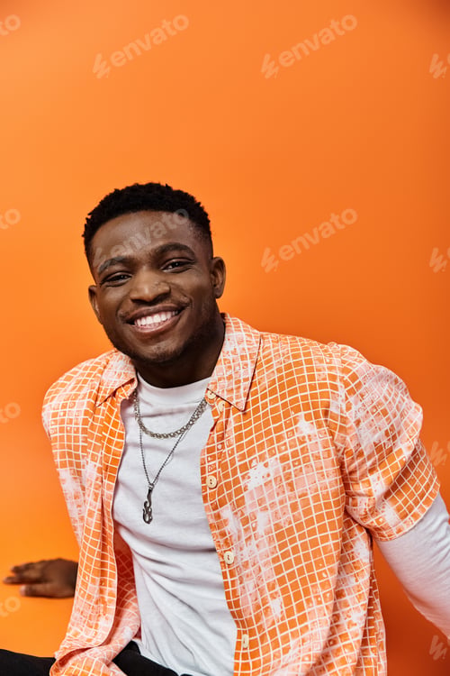 Preview: Vibrant Harmony: Man in Orange Shirt Against Orange Background