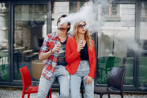 Preview: Stylish young couple with vape in a city
