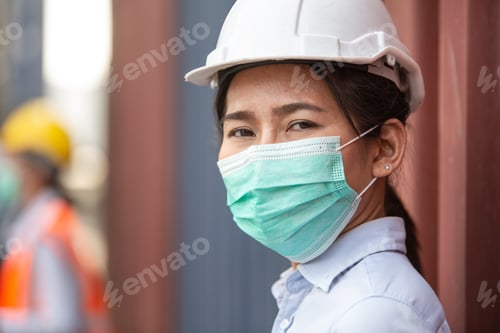 Preview: Asian woman worker wearing protective mask working at logistic warehouse