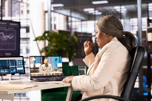 Preview: Team leader in office talking with regional manager in teleconference meeting