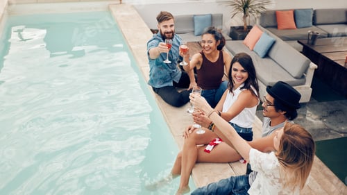 Preview: Group of friends toasting at pool party outdoor