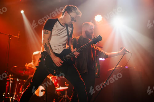 Preview: Guitarist performing with band on stage during concert